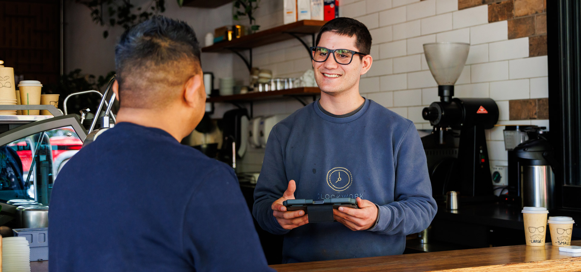 A man serves a customer at a coffe shop