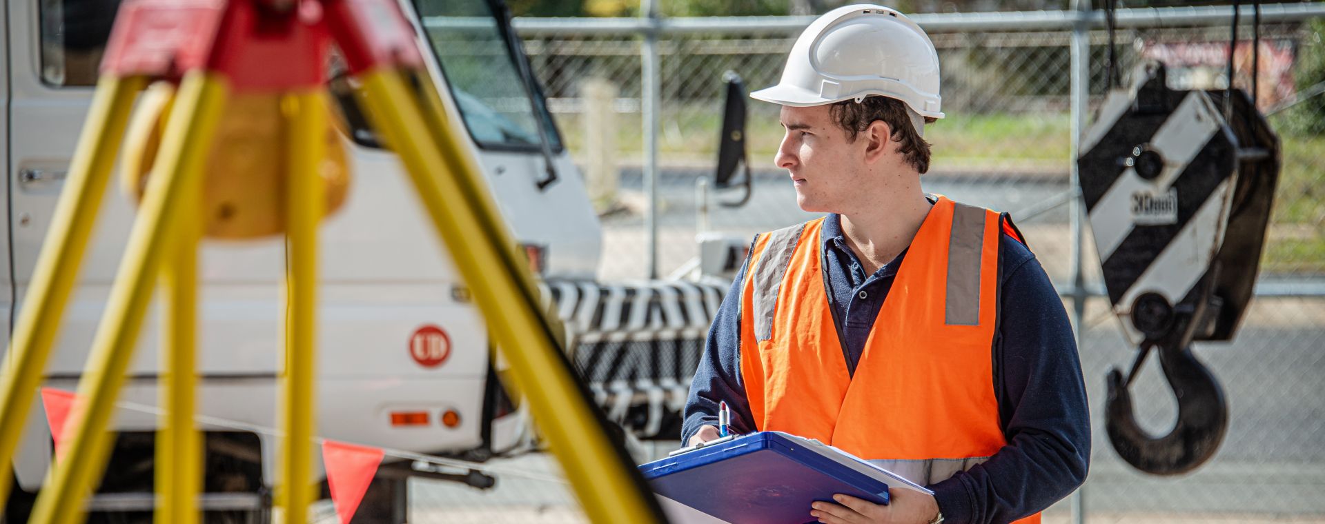 Engineer on site holding a clipboard.